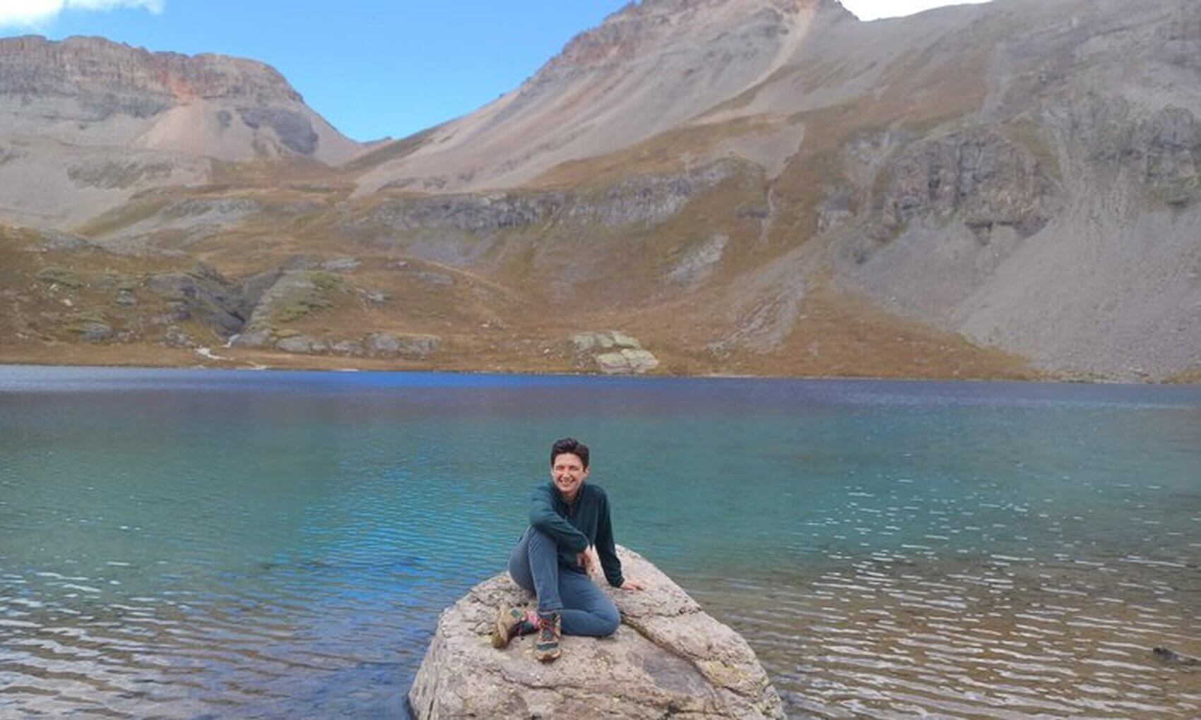 Rachel, a software engineer at Lightship, poses in front of Ice Lake in the San Juan National Park